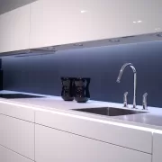 Chiuvetă din inox într-o bucătărie, cu scurgerea în prim-plan, ilustrând cauzele mirosului urât din chiuvetă și soluțiile pentru eliminarea lui
