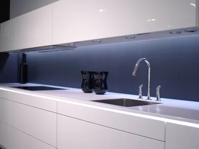 Chiuvetă din inox într-o bucătărie, cu scurgerea în prim-plan, ilustrând cauzele mirosului urât din chiuvetă și soluțiile pentru eliminarea lui