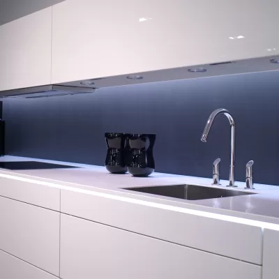 Chiuvetă din inox într-o bucătărie, cu scurgerea în prim-plan, ilustrând cauzele mirosului urât din chiuvetă și soluțiile pentru eliminarea lui